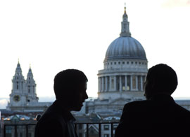 Two alumni on a balcony in front of St. Paul's cathedral, London, at an Emory networking event.