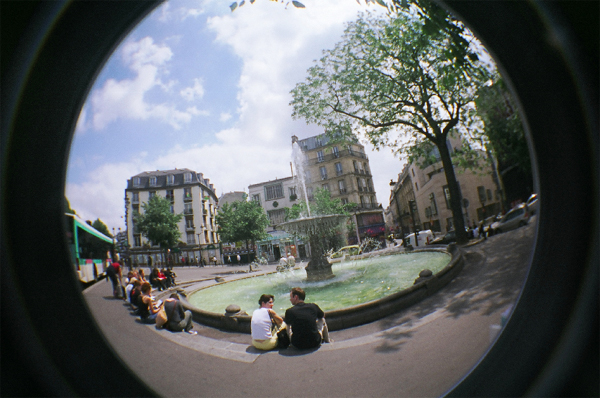 People sitting by fountain, photo from Alloy