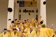 Golden-robed Class of 1959 tosses hats in the air on steps of Phi Gamma Hall