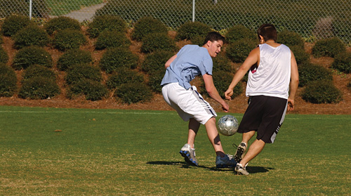 Two students playing soccer