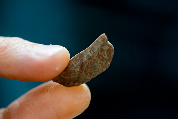 A brown rock in between fingers
