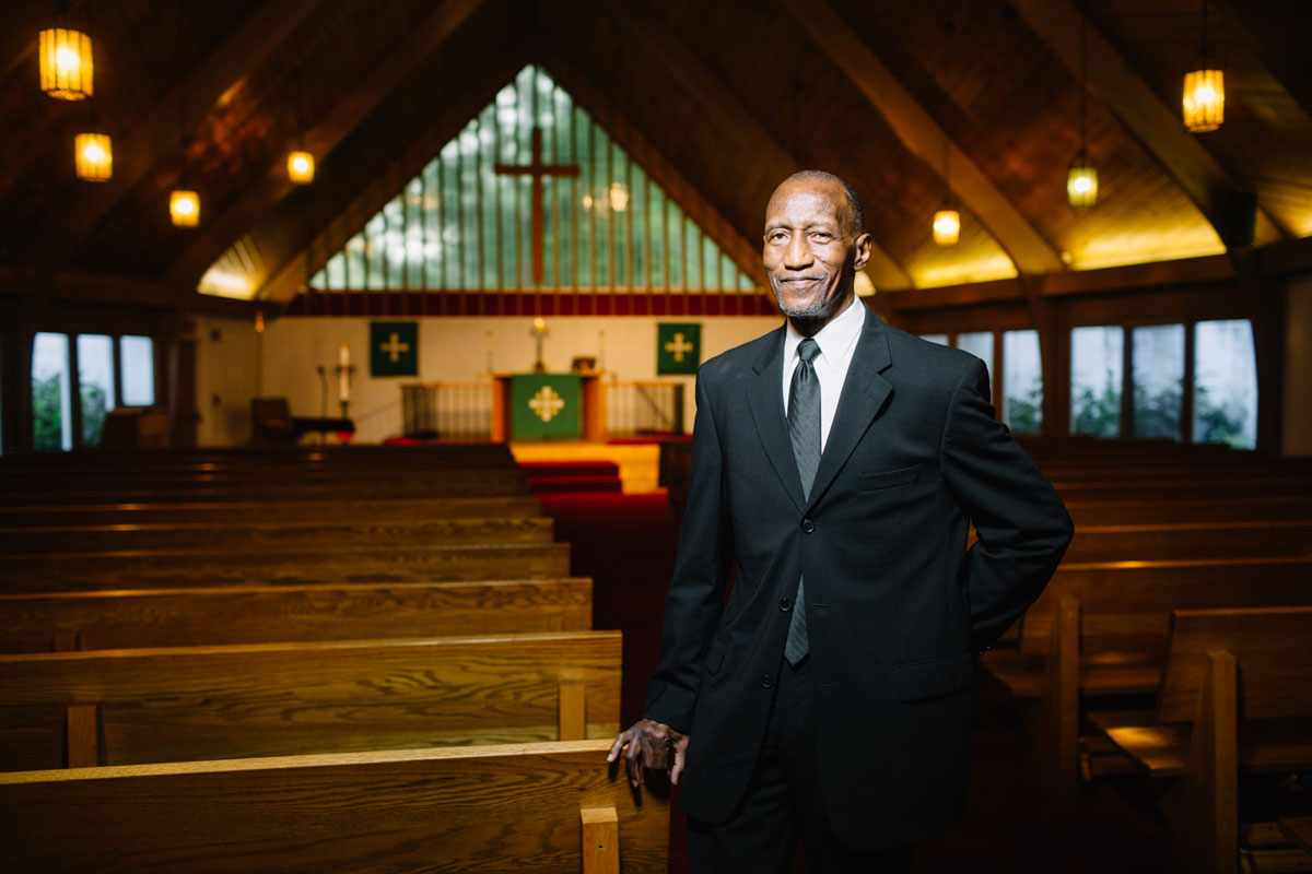 Carl McKinney stands in the sanctuary of a church with the altar in the distant background.